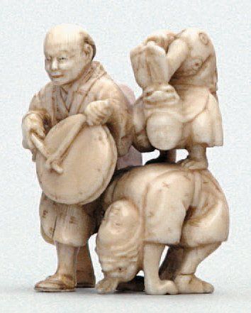  OKIMONO en ivoire représentant un musicien jouant du tambour pour accompagner deux...