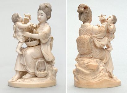  OKIMONO en ivoire représentant une mère jouant avec son enfant, des paniers de fleurs...
