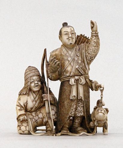  OKIMONO en ivoire représentant un samouraï et un archer, un chien à leurs pieds....