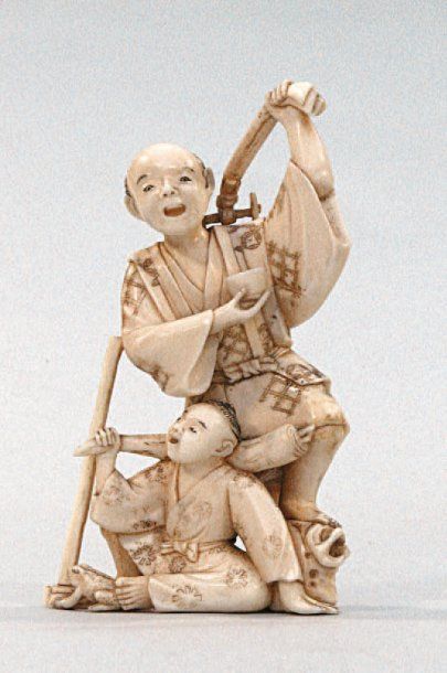 null OKIMONO en ivoire représentant un paysan ivre dansant, devant lui un enfant...