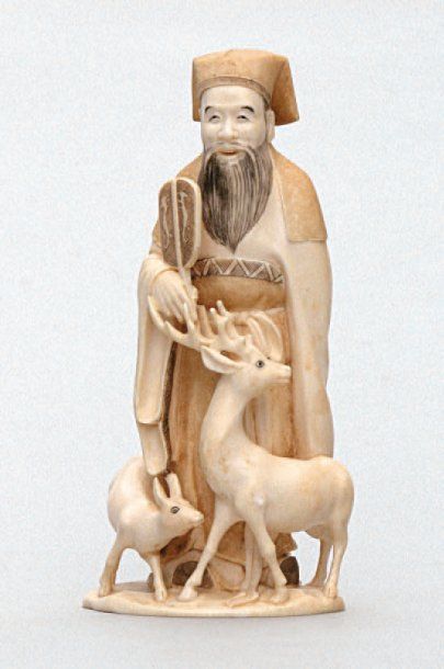 null OKIMONO en ivoire représentant un sage tenant un ushiwa, à ses pieds une biche...