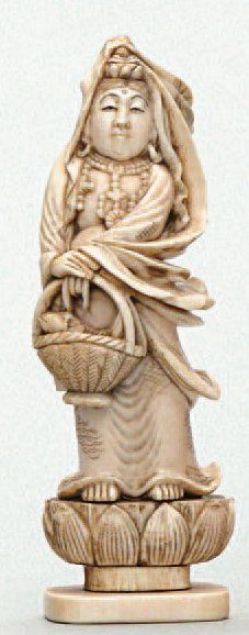  OKIMONO en ivoire représentant Benten debout, sur une fleur de lotus, elle porte...