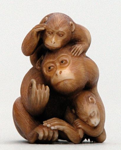 null NETSUKE en ivoire représentant un singe s'épouillant accompagné de deux petits,...