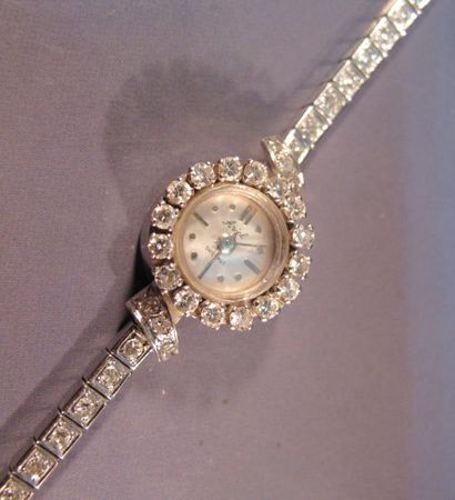null Montre bracelet de dame en or gris à boîtier rond serti d'un rang de diamants,...