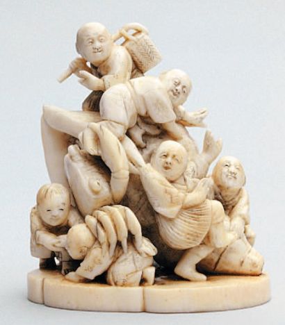 null OKIMONO en ivoire représentant six enfants autour d'une conque géante essayant...