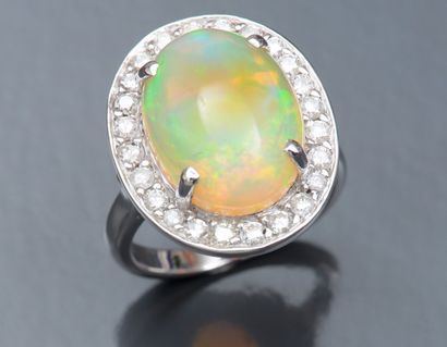 null Bague en or gris 750°/00 (tête d'aigle) centrée d'une opale ovale de 9 carats...