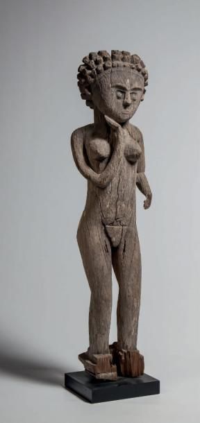 null MAHAFALY, Madagascar. Statue féminine en bois érodé à patine de pluie, elle...
