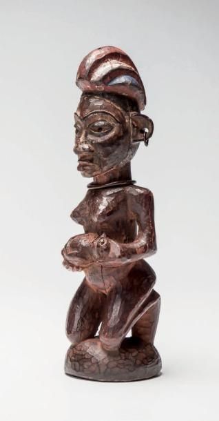 null YAKA, Congo (R.D.C.). Figure féminine en position agenouillée tenant son bébé...