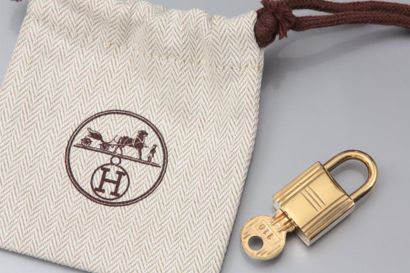 HERMES Cadenas de sac à main plaqué or, avec sa clé, pochette. Signé
