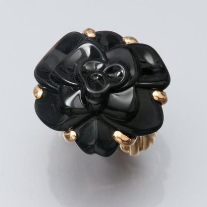 CHANEL Bague Camélia en or jaune 750°/00 (tête d'aigle), sertie d'onyx gravé. Moyen...