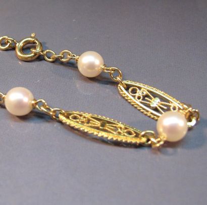 null Bracelet en or jaune à maillons ovales filigranés alternés de perles de culture....