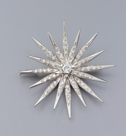 null Broche étoile en or gris 750°/00, centrée d'un diamant taille brillant , et...