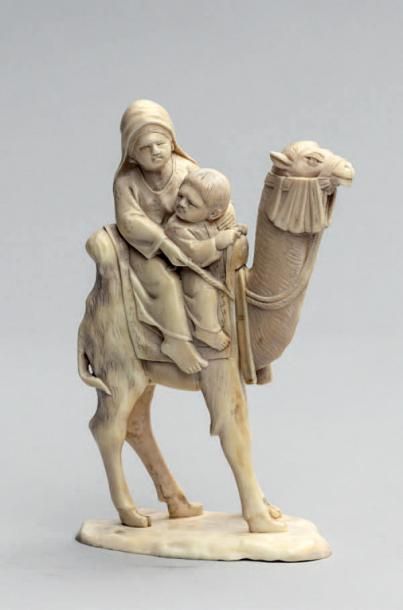 null OKIMONO en ivoire représentant une femme tartare et son enfant sur un chameau,...