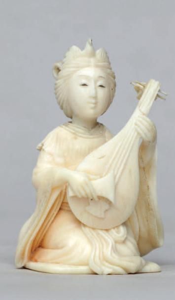 null OKIMONO en ivoire représentant une musicienne jouant du Shamizen, signé Nagatoshi.
Japon,...