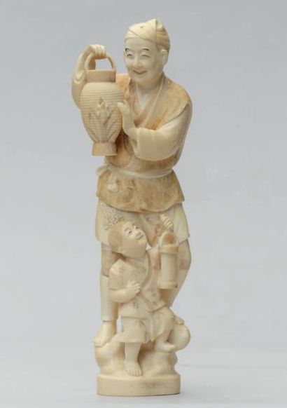 null OKIMONO en ivoire représentant un homme souriant portant une lanterne, son fils...