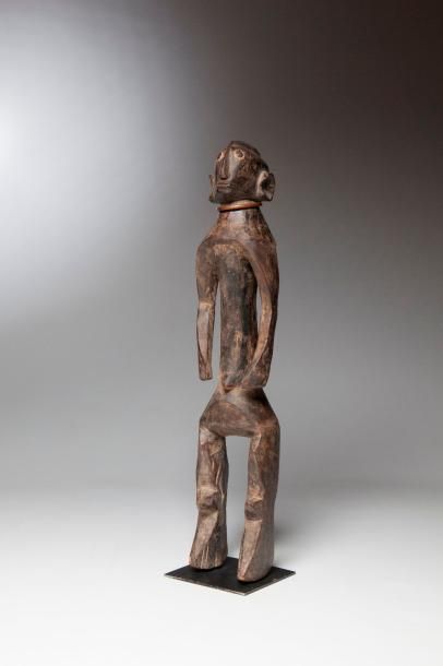 null MOUMOUYE, Nigéria. Statue en bois lourd, aux bras enveloppant un corps cylindrique,...