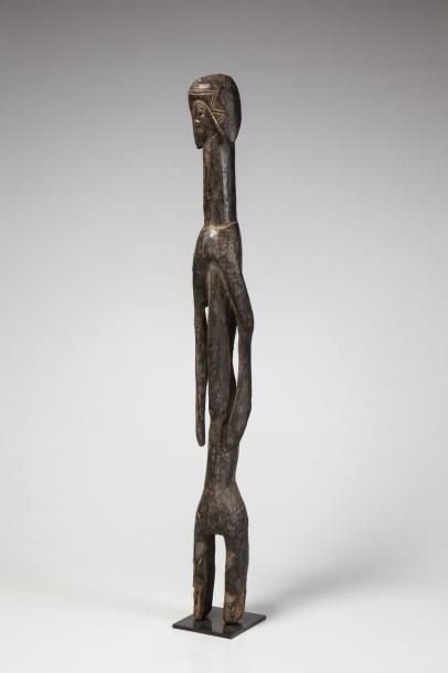 null MOUMOUYE, Nigéria. Statue longiligne en bois lourd à profonde patine sombre,...