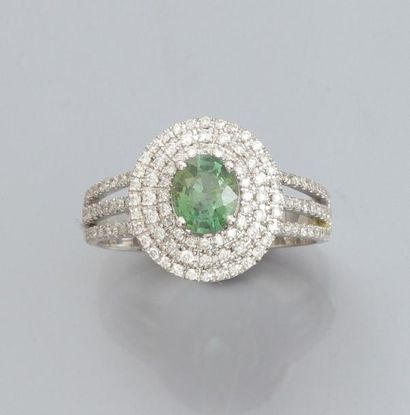 null Bague en or gris 750°/00, sertie d'un saphir vert ovale, double entourage de...