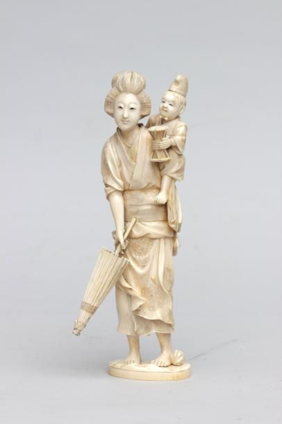 null OKIMONO en ivoire représentant une Mère tenat une ombrelle et portant son fils 
qui...