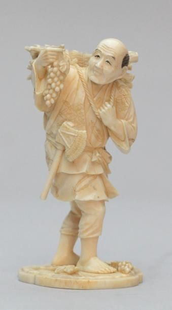 null OKIMONO en ivoire représentant un vigneron portant un fagot de sarments et une...