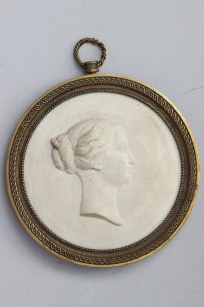 null MEDAILLON en biscuit représentant une jeune femme de profil, le cadre en bronze...