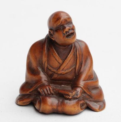 null Netsuke en bois teinté representant un homme assis, un evantail dans la main...