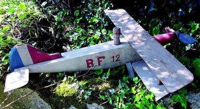 null -Grand avion de plancher en bois avec pilote, un aileron de l’empennage manquant....