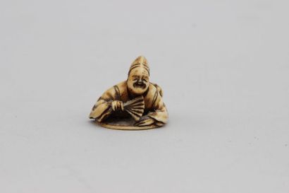 null NETSUKE en ivoire représentant un homme assis tenant un éventail, signé, Japon...