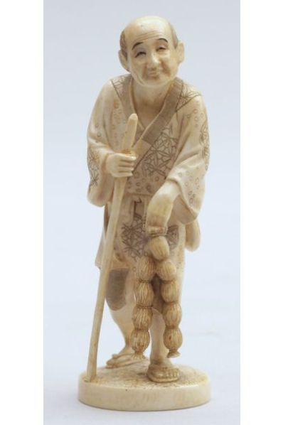null OKIMONO en ivoire représentant un paysan appuyé sur un bâton tenant deux bottes...