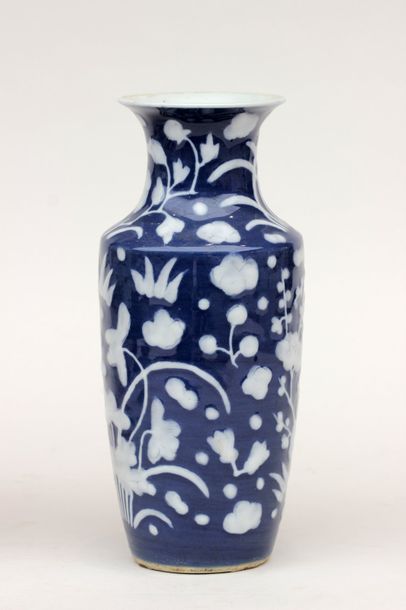 null VASE en porcelaine à décor en blanc sur fond bleu de motifs floraux en léger...