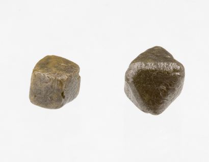  A lot of two rough diamonds, one in the shape of a cube and the other in the shape...