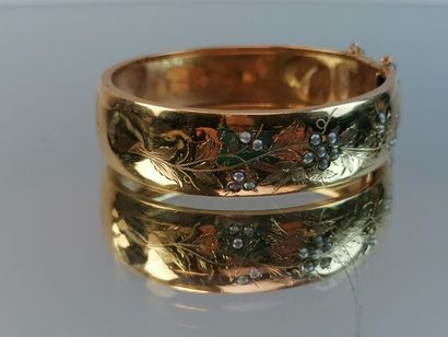 null Bracelet rigide en or jaune à décor de feuillage et petites demi perles de nacre....