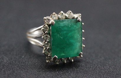 null White gold marquise ring set with a rectangular green stone in a setting of...