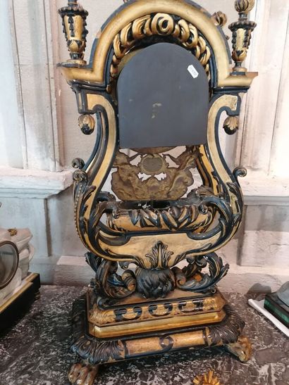 null Carved clock in blackened and gilded wood, it rests on a lion's head and is...
