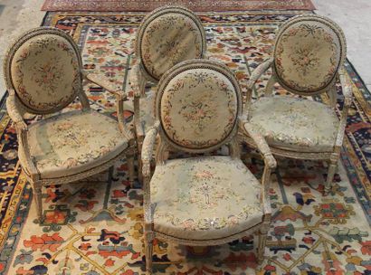 null Suite de 4 fauteuils à dossier médaillon en bois rechampi gris sculpté de rubans...