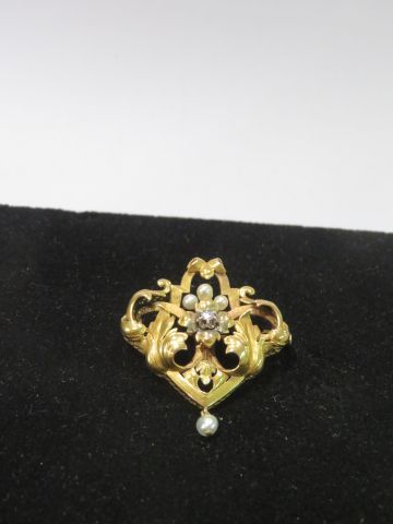 null Broche en or 18K, ornée de 4 perles de culture et centrée d'un brillant monté...