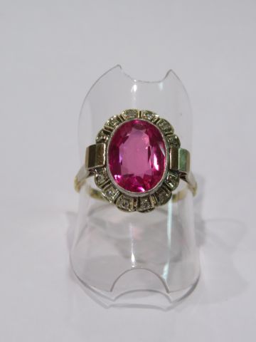 null Bague en or jaune 18K, ornée d'un cabochon rose en serti clos dans un entourage...