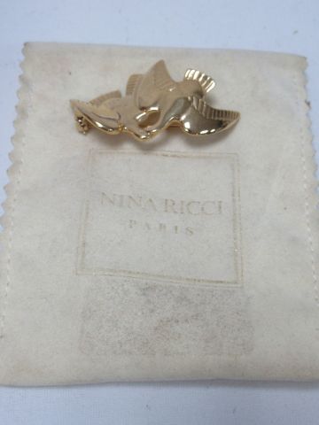 null Nina RICCI Broche en métal doré, à décor de colombes. Long.: 5 cm Dans son ...