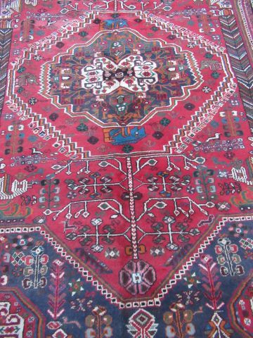 null CHIRAZ Tapis en laine à décor géométrique sur fond rouge et bleu. 291 x 202...