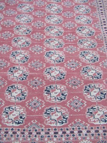 null PAKISTAN Tapis Boukhara en laine, à décor géométrique sur fond rose. 240 x 152...