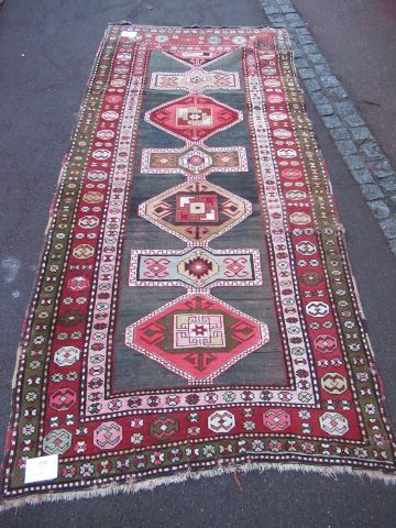 null CAUCASE Ancien tapis Kazak en laine à décor géométrique sur fond rouge et noir....