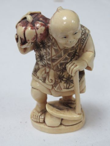 null 
JAPON Netsuke en ivoire teinté, figurant un homme à la canne. Vers 1900. Haut.:...