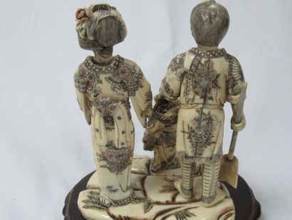 null 
JAPON Groupe en ivoire, figurant un couple avec leur enfant. Traces de polychromie....