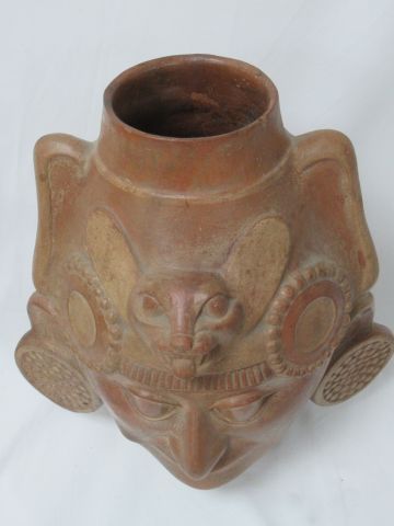 null 
PEROU Vase en terre cuite, en forme de visage, surmonté d'une tête de jaguar....