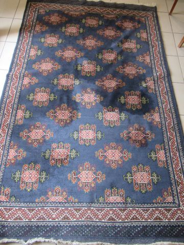 null Turkman wool carpet, decorated with pink medallions on a dark blue background....