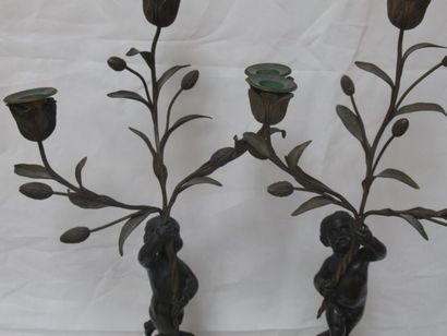 null A pair of bronze and marble candelabras decorated with putti holding flowers....