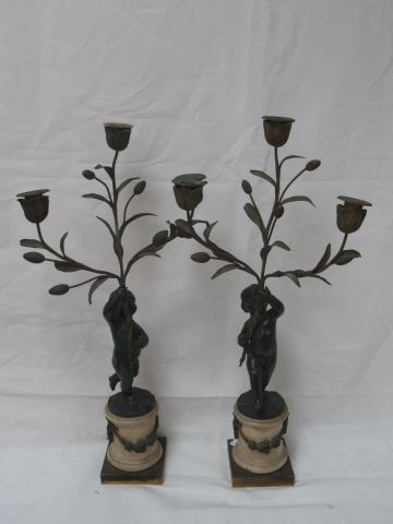 A pair of bronze and marble candelabras decorated...