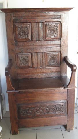  Carved natural wood cathedra (or armchair), the back decorated with four medallions....