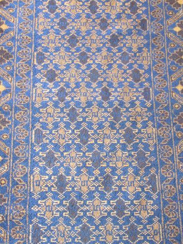 null Beloutch wool carpet, decorated with stylized plants on a brown and blue background....
