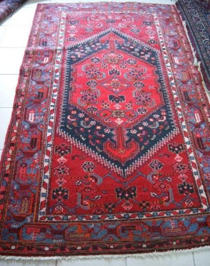 null Tapis persan (Hamadan) en laine à décor de médaillon sur fond rouge. Dim. :...